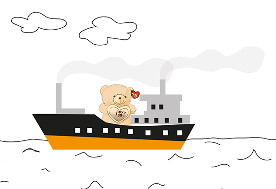 Das Bild zeigt ein Frachtschiff, das auf dem Meer fährt. Auf dem Schiff befindet sich ein hellbrauner Teddybär mit einem Plüschherz.